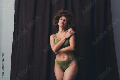 Photo of lovely young lady enjoy hug self dressed khaki lingerie studio background no filter self acceptance all body perfect