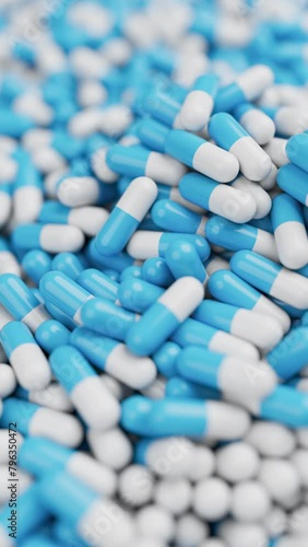 Closeup of White and blue pills mixing and spin in slow motion with shallow DOF. Drugs, pills, tablets, medicine concept. 3d render animation. Vertical video (ID: 796350472)