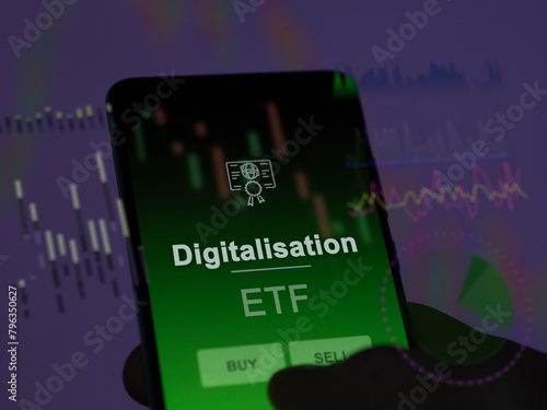An investor analyzing the digitalisation etf fund on a screen. A phone shows the prices of Digitalisation