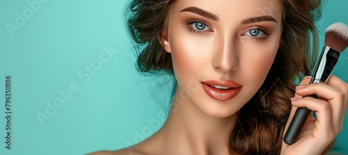 Graceful woman with brown curls holding makeup brush on soft pastel background for text placement photo