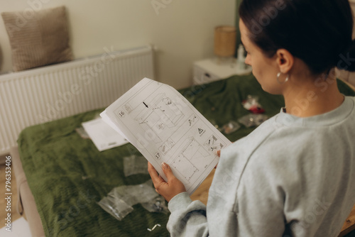 Woman reading an instruction manual to assemble furniture