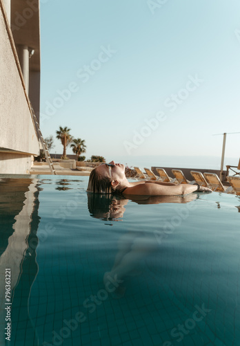 Happy woman enjoying the sun and water at the pool. Lifestyle and summer concept