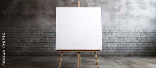 Easel displaying white canvas against brick wall