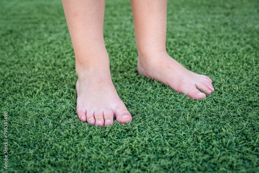 Kid feet on the green grass