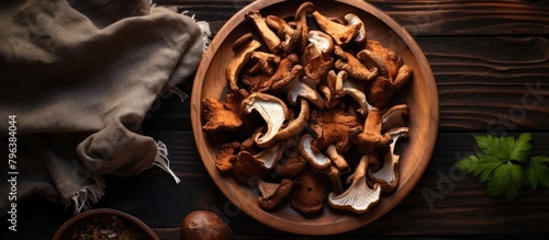 Wooden bowl with assorted mushrooms on table