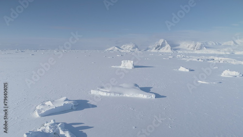 Antarctic polar winter. Frozen ice ocean water up to horizon. Aerial view of iceberg locked in ice Antarctica landscape. Polar Frozen ocean covered with snow. South nature landscape coastline