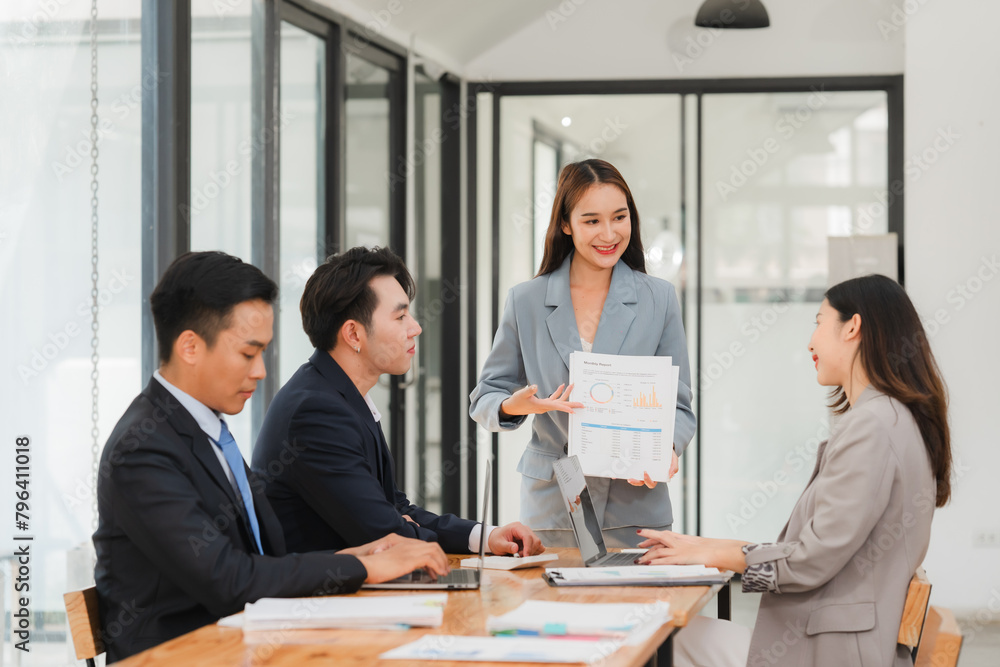Group of businesspeople are sitting around a table in a business setting. They are all smiling and seem to be enjoying each other's company Group of businesspeople are sitting around a table in a business setting. They are all smiling and seem to be enjoying each other's company