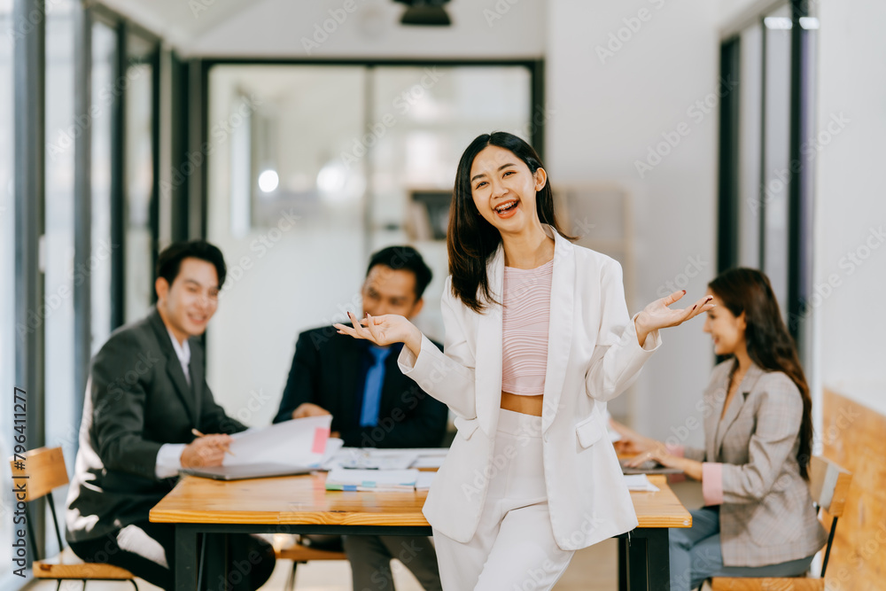 Group of businesspeople are sitting around a table in a business setting. They are all smiling and seem to be enjoying each other's company Group of businesspeople are sitting around a table in a business setting. They are all smiling and seem to be enjoying each other's company