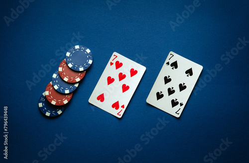 Luck in a poker game with a winning one pair combination. Playing cards and chips are laid out in a club on a blue table