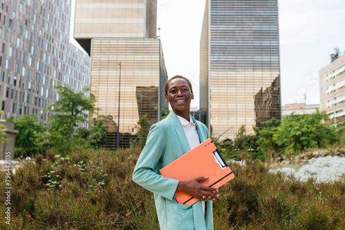 Confident businesswoman with documents in urban setting