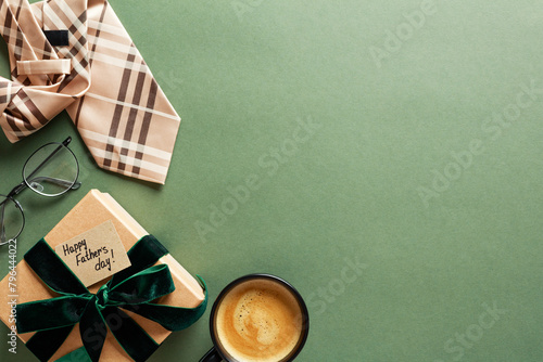 Fathers Day holiday greeting card template. Flat lay gift box with tag Happy Fathers Day, coffee cup, necktie, eyeglasses on green table.