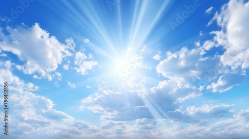 b'Blue sky and white clouds with sun rays shining through' photo