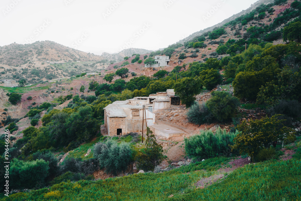 A building on a hill, overlooking the sky, trees, and mountains in Morocco
