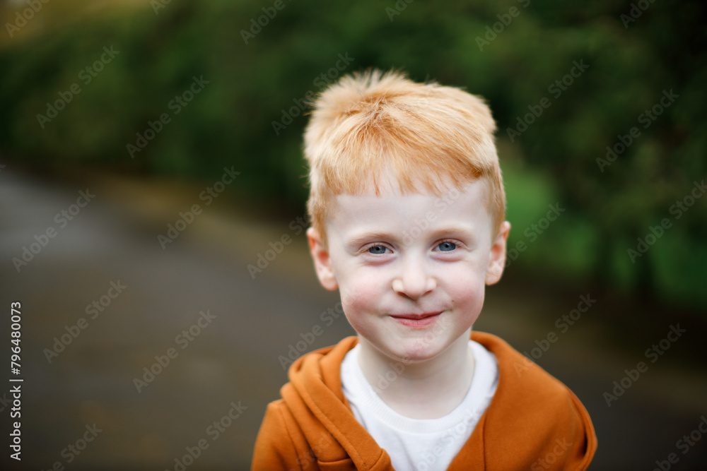 Portrait of a red-haired boy who is smiling. Blue eyes and a stylish suit Portrait of a red-haired boy who is smiling. Blue eyes and a stylish suit