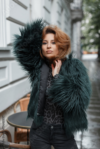 Beautiful young redhead woman model in fashion clothes with jacket posing in the city