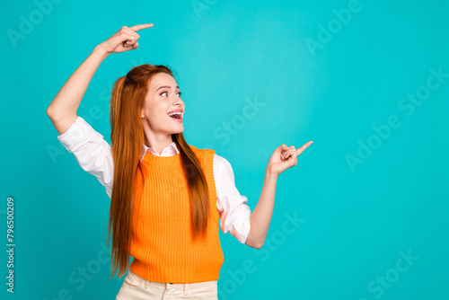 Photo portrait of pretty young girl point look shocked empty space wear trendy orange knitwear outfit isolated on cyan color background