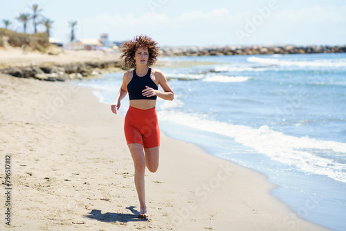 Fit sportswoman running on sandy beach