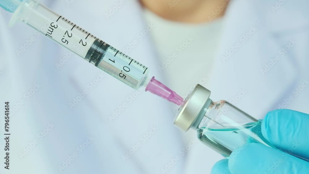 doctor's hand holds a syringe and a blue vaccine bottle at the hospital. Health and medical concepts.
doctor's hand holds a syringe and a blue vaccine bottle at the hospital. Health and medical concepts.