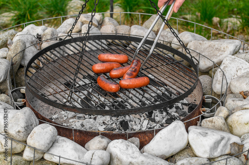 Kiełbasa obracana na rozpalonym grillu z bliska