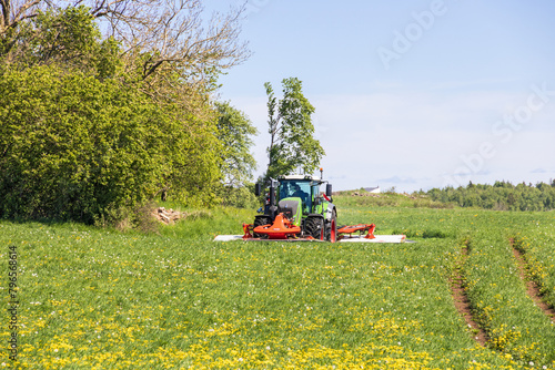 Tractor harvesting grass on a field