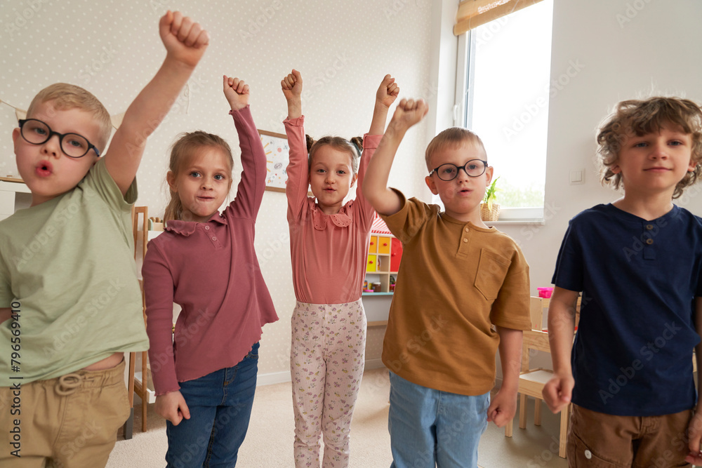 Fototapeta premium Preschool children with hands raised