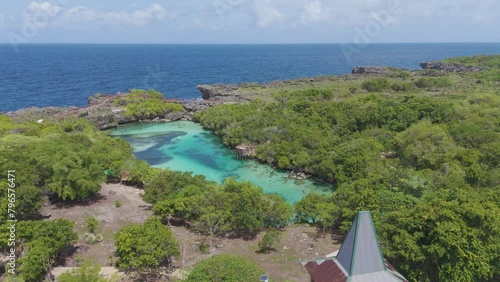 Weekuri Lagoon, Sumba island, Indonesia. A beautiful blue lake with a green forest in the background. The water is calm and clear, and the trees are lush and green photo