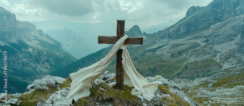 Picturesque landscape of an old wooden cross with a scarf of white fabric against a backdrop of mountains and blue sky. Faith, Orthodoxy, symbol of hope. photo