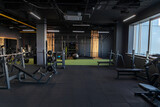 Dark gym interior with sports equipment, empty room in the morning