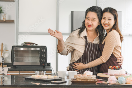Happy asian family senior mother and daughter cooking in kitchen