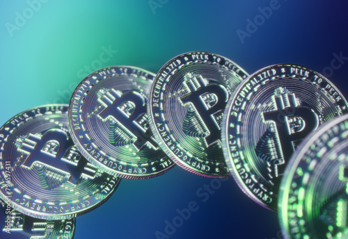 An array of floating Bitcoins, hovers over a minimalist, colorful, clean tech surface, with a slight blur. Green reflections and high detail reveal the architecture of the blockchain.  (ID: 796597431)
