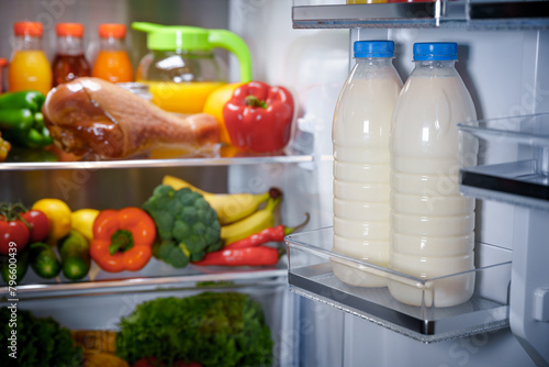 Products in the refrigerator. Bottles of milk in the fridge