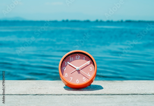 clock on a wooden pier next to the water © nito