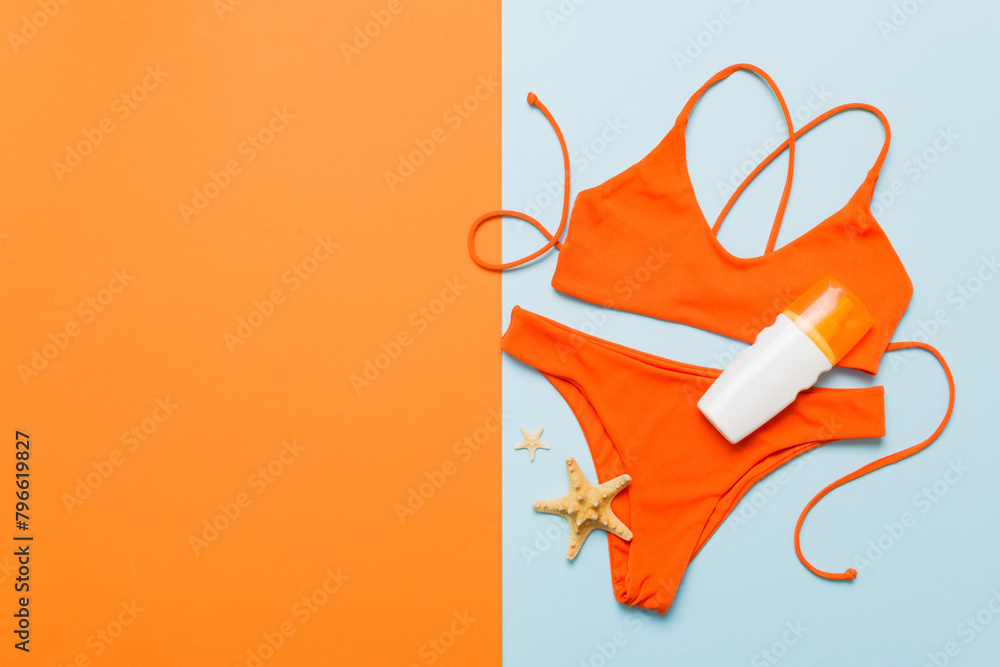 Naklejka premium Traveler accessories, women summer bikini set swimsuit on table background with empty space for text. Travel vacation concept. Flat lay, top view Female sexy swimwear
