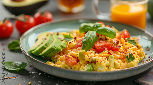 scrambled egg with tomatoes basil leaves avocado slices chili flakes and a cup of coffe and a glass of orange juice