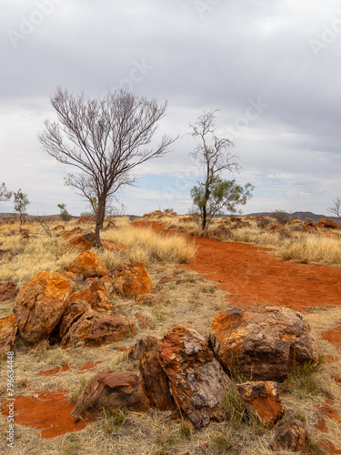 grey sky red dirt and rocky outcrop in Central Australia photo