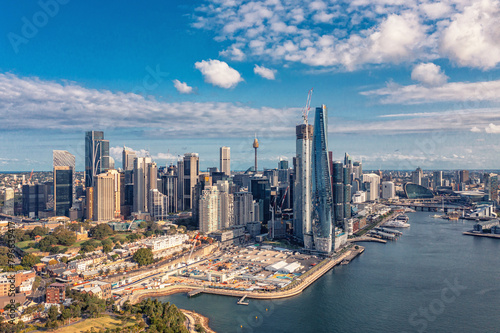 Aerial view modern skyscrapers and buildings near ocean and cloudy sky. Sydney, Australia. © romankrykh