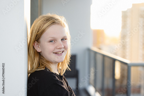 Pre-teen boy leaning against wall on balcony of high rise building on the Gold Coast photo