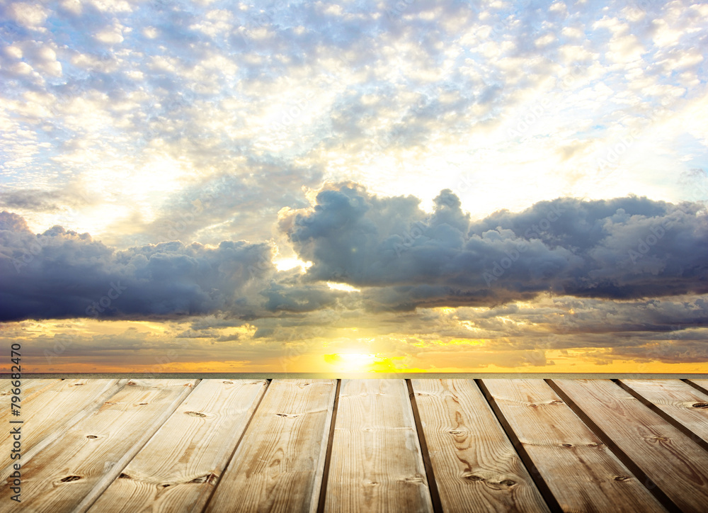 Wooden table with gray cloud background with sunset light