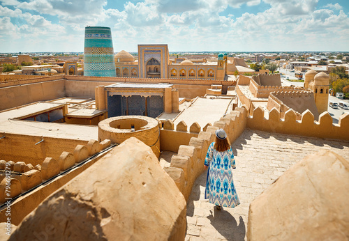 Tourist in ethnic dress at city walls Ichan Kala of Khiva photo