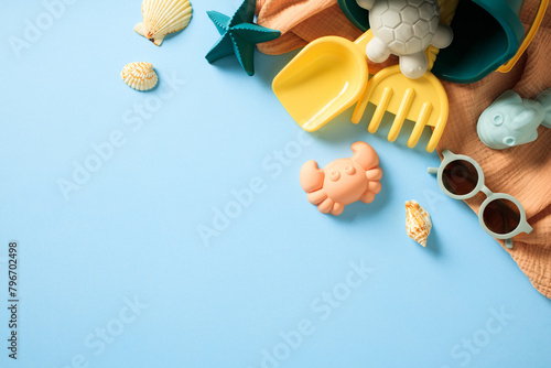 Children's beach sand toys and sunglasses on blue background. Summer, vacation concept.