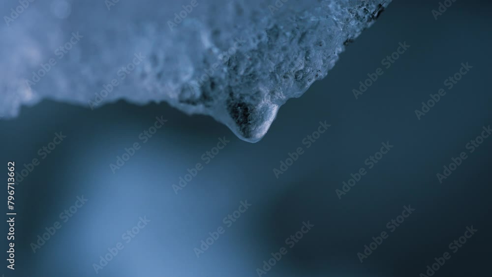Spring snow melting, macro shot of water droplets in slowing down dripping. Global warming, melting of glaciers. Spring snow melting, macro shot of water droplets in slowing down dripping. Global warming, melting of glaciers.