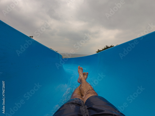 Man going down a water slide showing legs and feet  © Cam