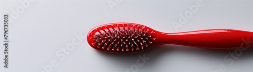 Bright red hair styling tools, a comb and dryer, lie isolated on a crisp white background photo