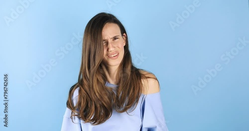 Perplexed dissatisfied woman looks frustrated at camera says I don't agree has puzzled face expression dressed casually isolated over blue background. Girl shake her head. No, deny. photo