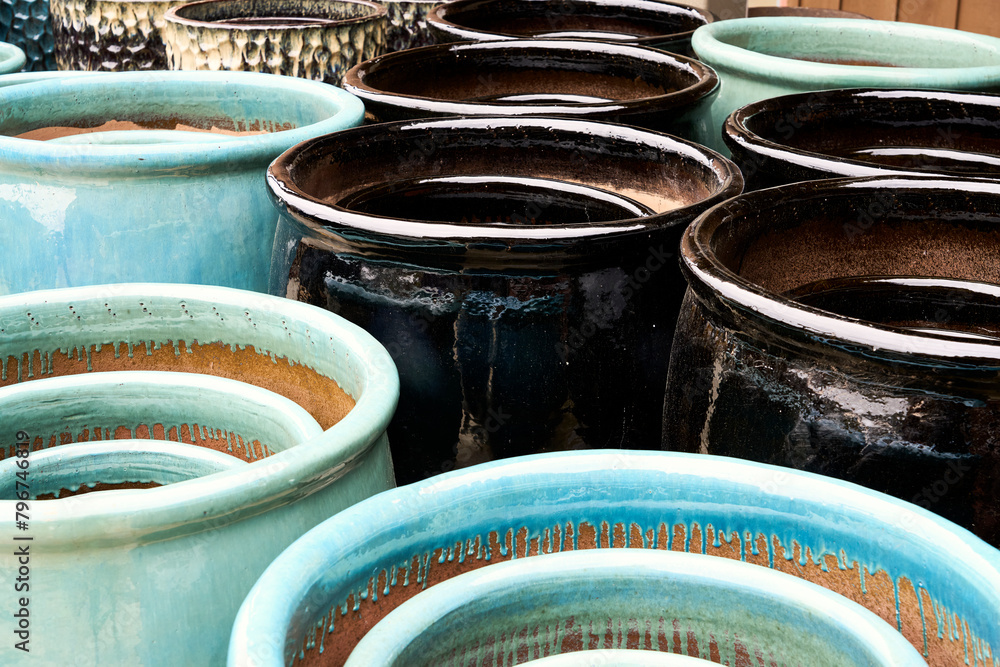 Beautiful large teal plant pot in front of brown plant pots for sale at a market garden. Beautiful large teal plant pot in front of brown plant pots for sale at a market garden.