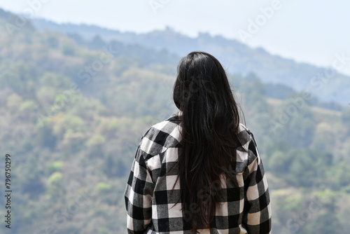 Chica joven Guatemalteca de espaldas admirando el paisaje en las montañas de Guatemala, concepto de paz y relajación. photo