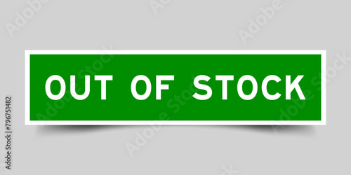 Green color square label sticker with word out of stock on gray background