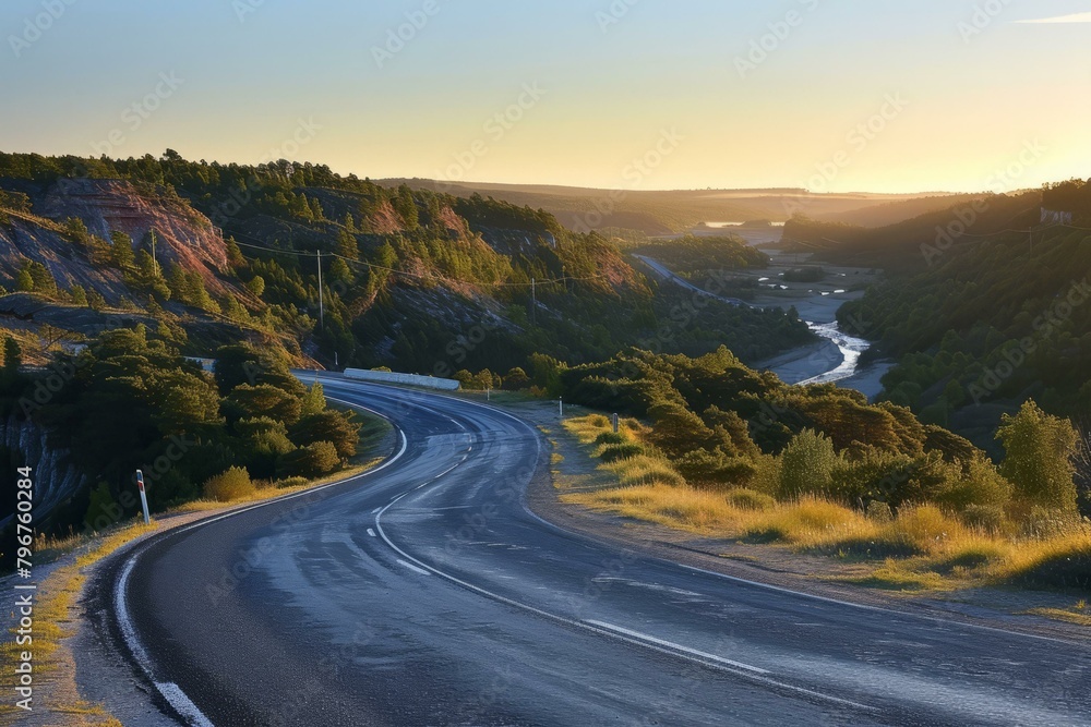 b'Winding road through a valley at sunset'