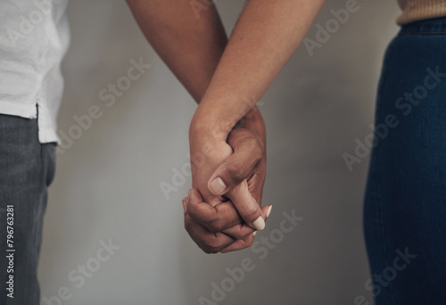 Couple, love and holding hands for support, care and solidarity or romance with studio background. Compassion, partnership or relationship for people, marriage or hope or trust for affection together