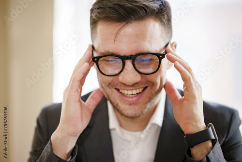 Tableau sur toile An upbeat executive with glasses exudes joy, showcasing the lighter side of business in a comfortable office setting